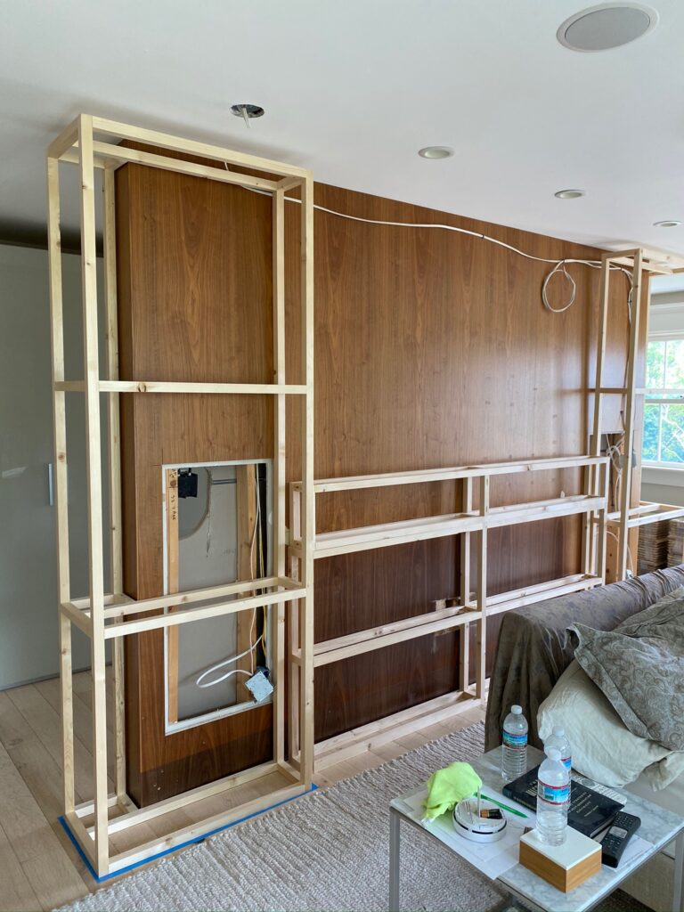 Extending divider wall adding dimension and shelf behind headboard of modern queen bed